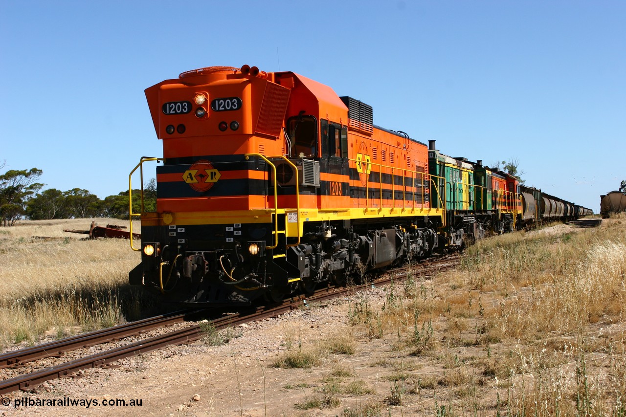 060111 2333
Warramboo, located at the 190.2 km and opened with the line in May 1913, with now disused station building on the left, Clyde Engineering built EMD G12C model loco 1203 serial 65-427 stands on the mainline as loading on the grain siding has started. 11th January 2006.
Keywords: 1200-class;1203;Clyde-Engineering-Granville-NSW;EMD;G12C;65-427;A-class;A1513;