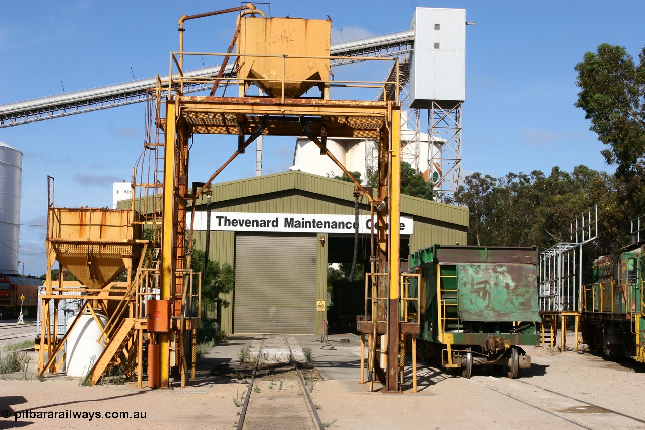 060113 2453
Thevenard Maintenance Centre overview, sanding tower in front of workshop, ENH type hopper waggon. Empty train 6DD3 sneaks beside the no longer rail served grain silos at left. 13th January 2006.
