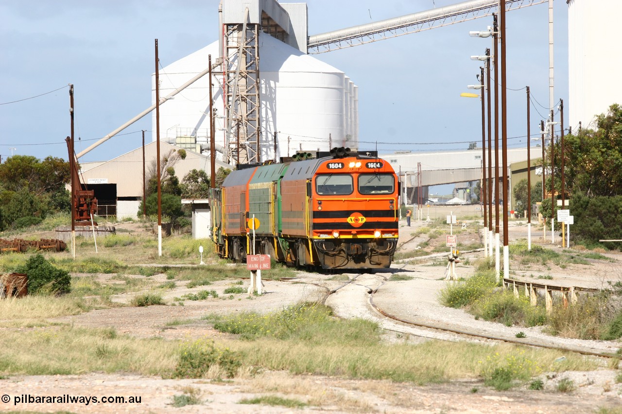 060113 2462
Thevenard, narrow gauge loco 1604 with a fresh crew depart the yard with empty train 6DD3, 1604 leads a triple consist of Clyde Engineering built EMD JL22C model 1600 / NJ class combination of 1604 serial 71-731 and originally NJ 4, NJ 3 serial 71-730 and 1601 serial 71-728 the original class leader NJ 1, all three units started on the Central Australia Railway in 1971 and were transferred to the Eyre Peninsula in 1981. 1604 and 1601 both renumbered in 2004. A roll-by is also being conducted by an outgoing crew member. 13th January 2006.
Keywords: 1600-class;1604;Clyde-Engineering-Granville-NSW;EMD;JL22C;71-731;NJ-class;NJ4;