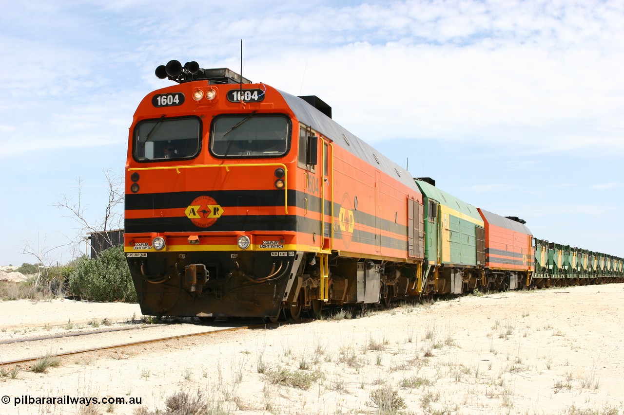 060113 2546
Kevin, narrow gauge locos 1604, NJ 3 and 1601 take the mainline to Thevenard, having reversed train 6DD3 on the Kevin triangle as they prepare to load, 1600 class unit 1604 in Australian Railroad Group livery a Clyde Engineering built EMD JL22C model serial 71-731, originally built as NJ class NJ 4 and built for the Central Australia Railway in 1971, transferred to the Eyre Peninsula in 1981. 13th January 2006.
Keywords: 1600-class;1604;Clyde-Engineering-Granville-NSW;EMD;JL22C;71-731;NJ-class;NJ4;