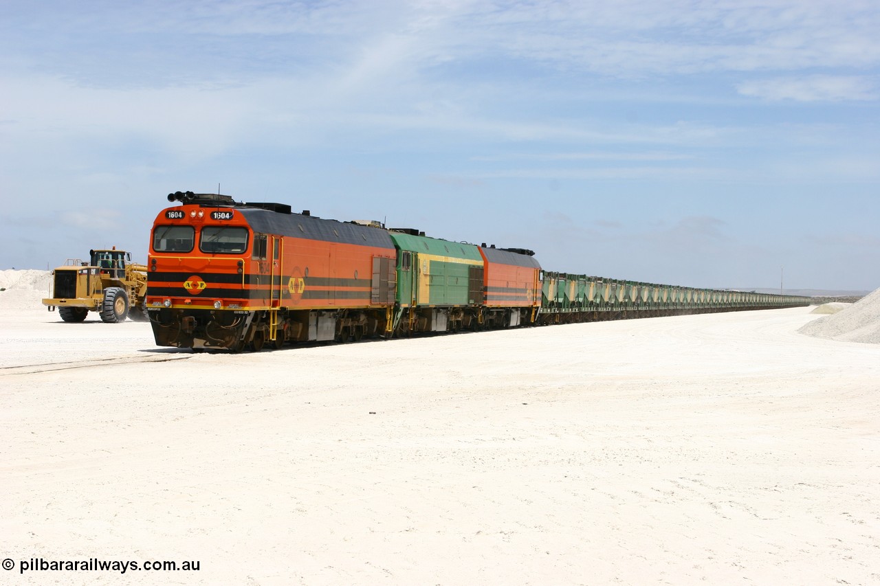 060113 2549
Kevin, standing on the mainline to Thevenard, and the train now identified as 6DD4 has commenced loading of gypsum but the 988 Cat front end loaders which takes about one and half hours to load. As the train reversed on the triangle the consist is the same heading back loaded with 1604 leading NJ 3 and 1601. 13th January 2006.
Keywords: 1600-class;1604;Clyde-Engineering-Granville-NSW;EMD;JL22C;71-731;NJ-class;NJ4;