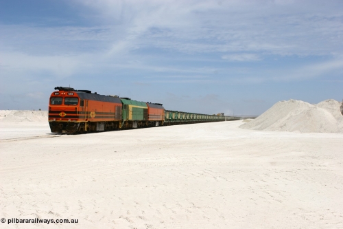 060113 2552
Kevin, standing on the mainline to Thevenard, and the train now identified as 6DD4 has commenced loading of gypsum but the 988 Cat front end loaders which takes about one and half hours to load. As the train reversed on the triangle the consist is the same heading back loaded with 1604 leading NJ 3 and 1601. January 13, 2006.
