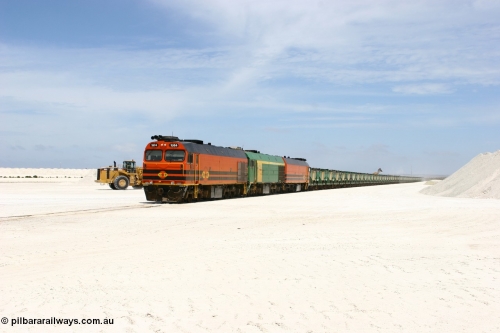 060113 2554
Kevin, narrow gauge locos 1604, NJ 3 and 1601 wait while their return working train 6DD4 is loaded on the mainline to Thevenard. The plant is behind the tipping loader and Kevin back around to the right behind the gypsum pile. January 13, 2006.
