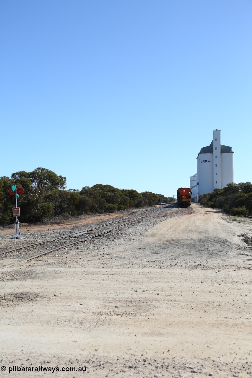 130703 0161
Murdinga, overview of the station yard looking north, siding point lever and indicator, Mallee style shelter train control building in the far distance on the left beside train, grain train loading on the siding, eight cell concrete grain silo complex with Ascom single cell behind it. [url=https://goo.gl/maps/LShPNnU33Qbmc1879]Geo location[/url]. 3rd July 2013.
