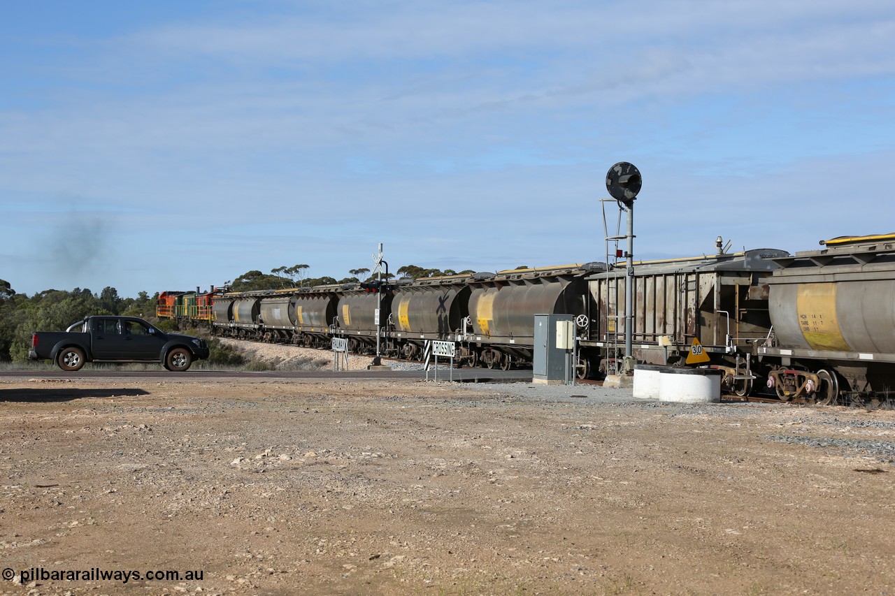 130704 0410
Kyancutta, south bound loaded grain train has stopped here to collect a loaded rack of grain waggons, seen here backing up to re-join the rest of the train on the mainline as it crosses the Eyre Highway grade crossing and one of only three electric signals on the network, behind EMD 1204 and twin ALCo 830 units 873 and 851. 4th July 2013.
