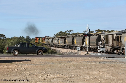 130704 0409
Kyancutta, south bound loaded grain train has stopped here to collect a loaded rack of grain waggons, seen here backing up to re-join the rest of the train on the mainline as it crosses the Eyre Highway grade crossing, behind EMD 1204 and twin ALCo 830 units 873 and 851. July 4, 2006.
