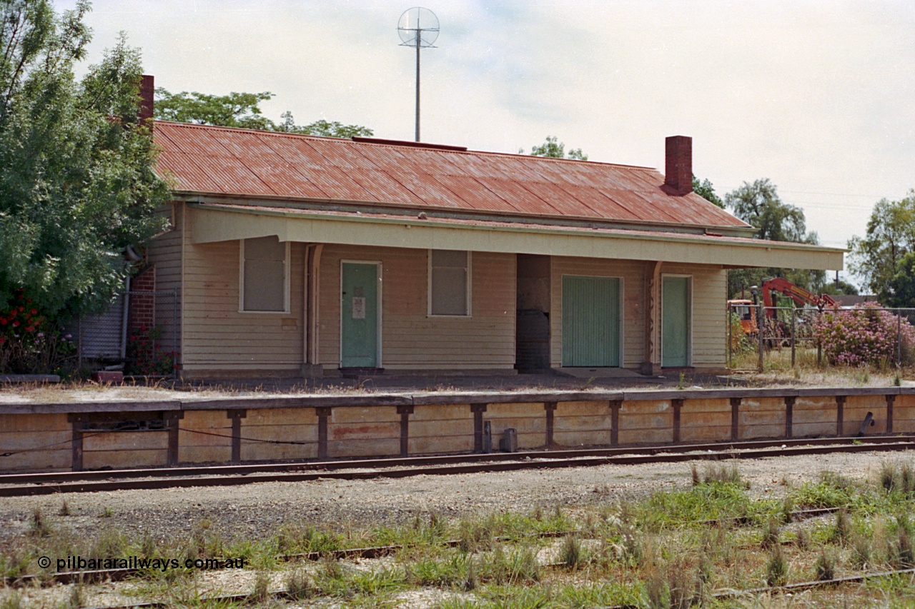 100-23
Rutherglen station building overview and platform, signal wires can be seen exiting the platform front, yard overgrown, disused.
