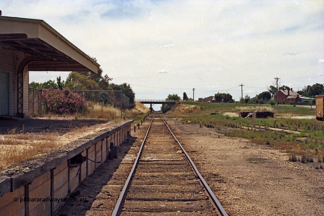 100-24
Rutherglen station yard overview, station building and platform, broad gauge track view looking towards Wahgunyah, High Street over bridge in distance, up home semaphore signal below, edge of yellow GY type four wheel open waggon at right.
Keywords: GY-type;fixed-wheel-waggon;