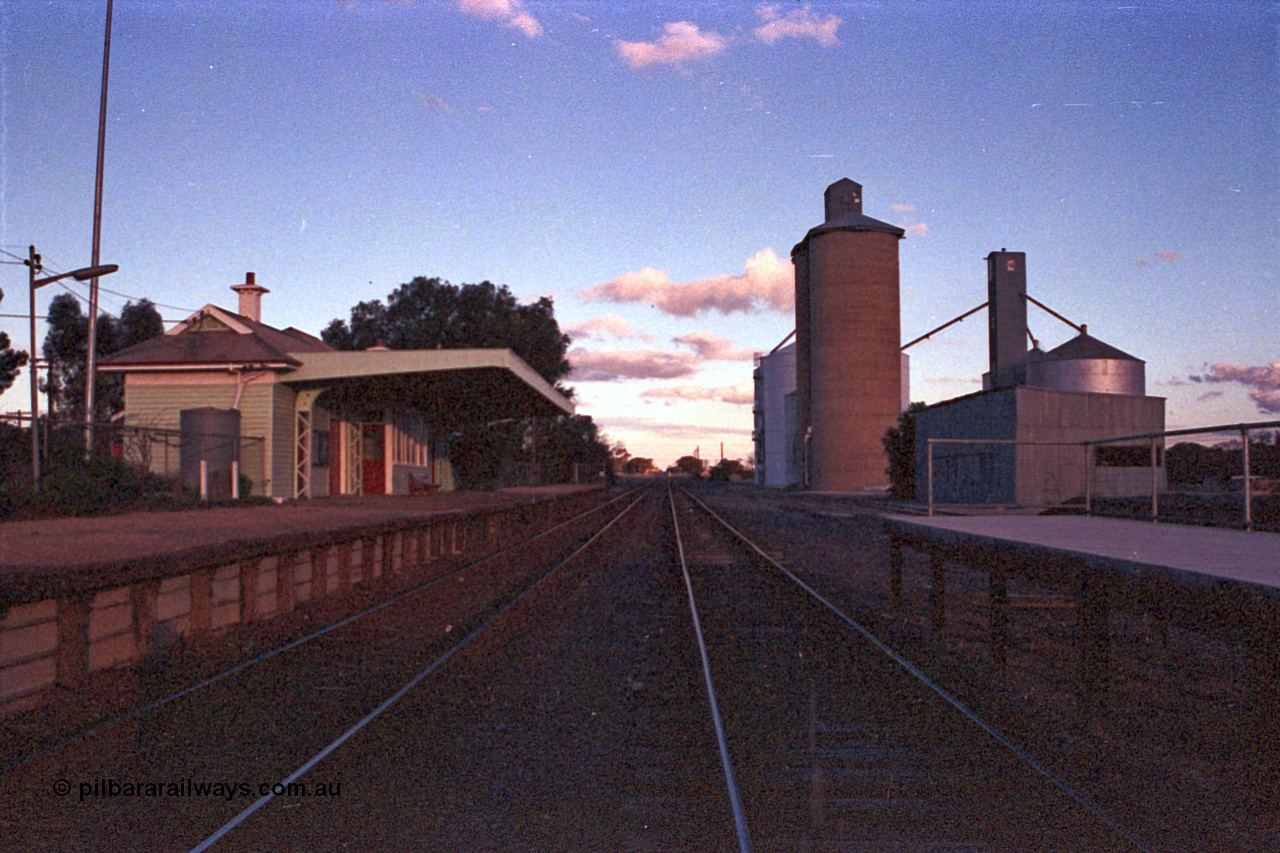 102-05
Woomelang station yard overview, station building and platform, new down platform at right, goods shed and Geelong style silo complex with Ascom new and old silos distant right, looking south.
