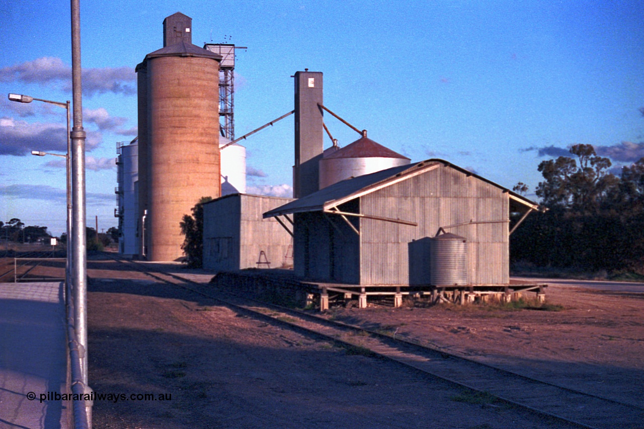 102-07
Woomelang yard view, station platform edge, goods shed and super phosphate shed, Geelong style and new and old style Ascom silo complexes, taken from down platform.
