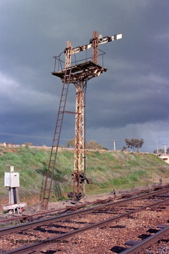 103-09
Springhurst, semaphore signal post 4 with the top of the dolls cut off and the signal for the Wahgunyah line, standard gauge flyover on bank, point rodding, looking south from No.2 Rd.
