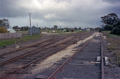 103-17
Wahgunyah station yard overview, super phosphate sheds on the left track, portable station building in middle of frame, silos in distance, scotch block and point levers in foreground.
