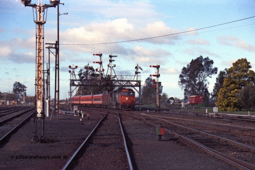 103-32
Benalla station yard overview looking north, broad gauge V/Line N class loco N 456 'City of Colac' with serial 85-1224 a Clyde Engineering Somerton Victoria built EMD model JT22HC-2 and N set with up Albury pass under the intact semaphore signal gantry, signal post 20 in front of camera, opposite B box, yard still interlocked.
Keywords: N-class;N456;Clyde-Engineering-Somerton-Victoria;EMD;JT22HC-2;85-1224;
