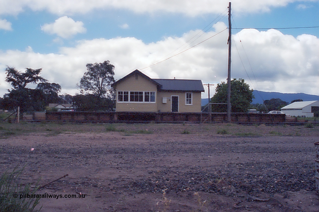 104-13
Buangor station building overview, front elevation of building, signal box and platform, very dark.
