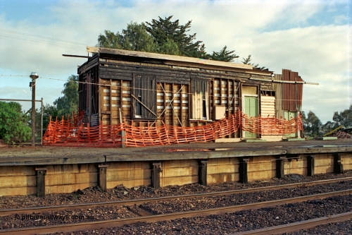 106-29
Nagambie station building, booking office end, has been on fire, signal levers just visible through bunting on platform, in the process of being demolished.

