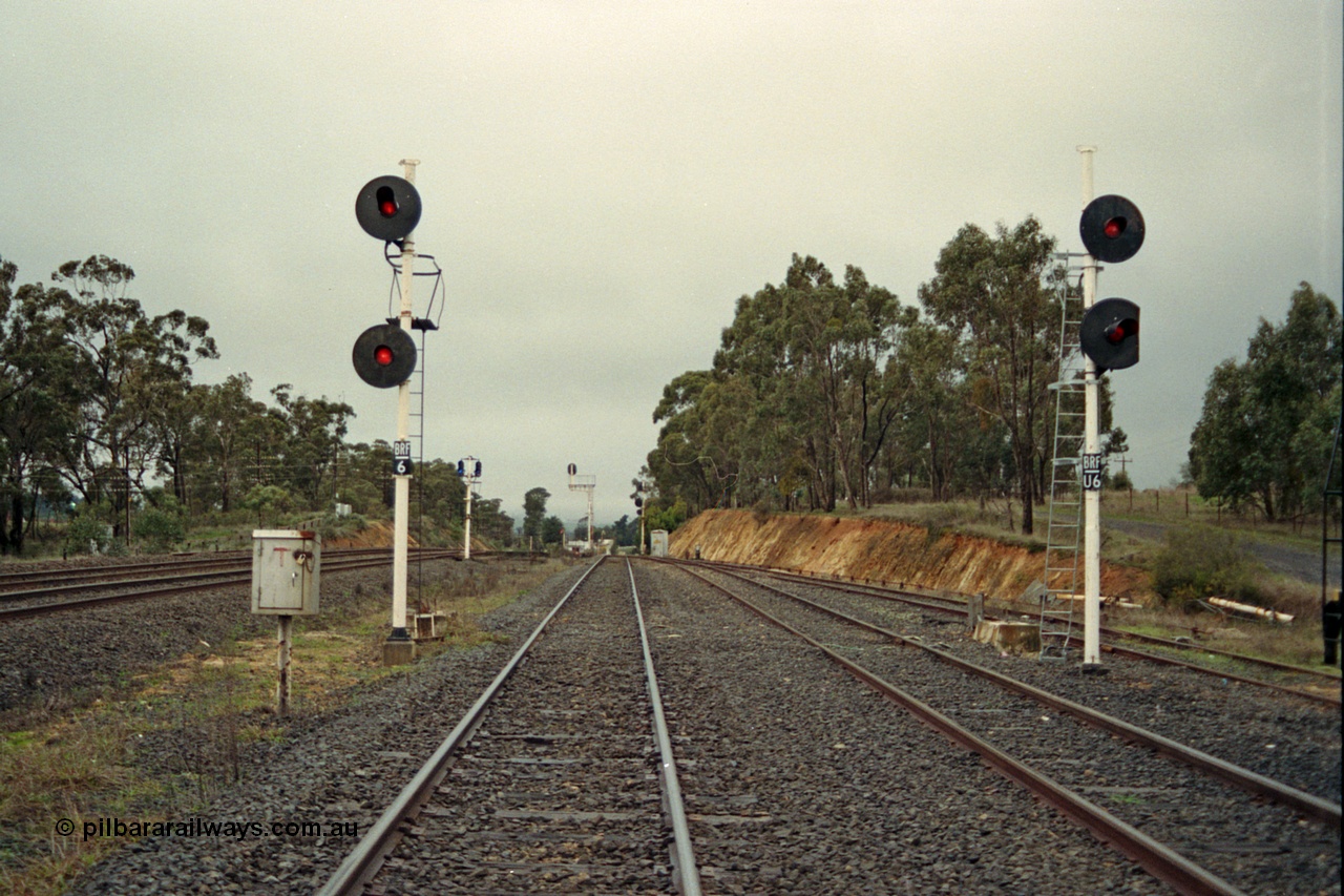 109-07
Broadford Loop, standard gauge, looking north, new searchlight signal posts BRF/6 and BRF/U6 on the right, former signal gantry footings behind posts, not BRF U6 lower target has been trimmed to allow gauge clearance on the ballast loading siding on the right, broad gauge mainline tracks to the left
