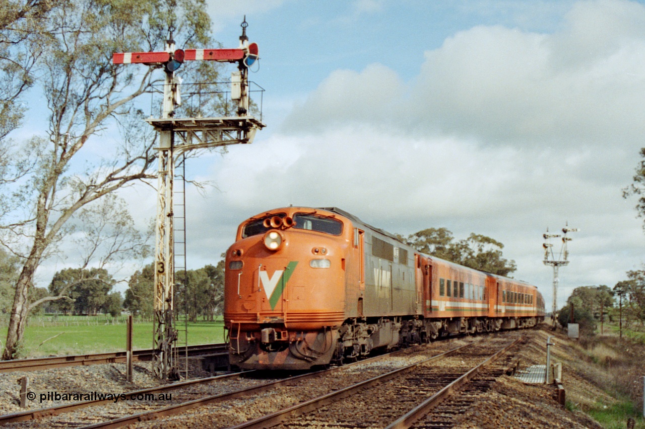 109-21
Violet Town, V/Line broad gauge A class A 66 Clyde Engineering EMD model AAT22C-2R serial 84-1186 rebuilt from B 66 Clyde Engineering EMD model ML2 serial ML2-7 and N set work a down Albury passenger train off the main an onto No.1 Rd past semaphore signal post 3, the standard gauge line is on the far left, semaphore signal post 2 in the background.
Keywords: A-class;A66;Clyde-Engineering-Rosewater-SA;EMD;AAT22C-2R;84-1186;rebuild;bulldog;