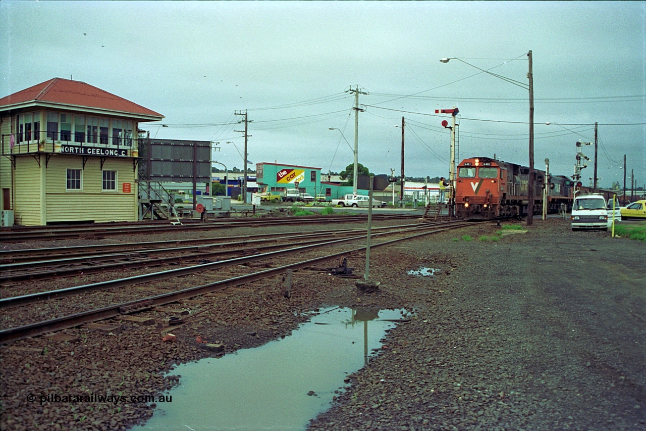 111-03
North Geelong C Box, V/Line broad gauge locos N class N 461 'City of Ararat' Clyde Engineering EMD model JT22HC-2 serial 86-1190 and X class X 47 Clyde Engineering EMD model G26C serial 75-794 pick up the electric staff for the grain loop, signaller on the staff exchange platform, signal box, ground dwarf disc signal, semaphore signal posts.
Keywords: N-class;N461;Clyde-Engineering-Somerton-Victoria;EMD;JT22HC-2;86-1190;