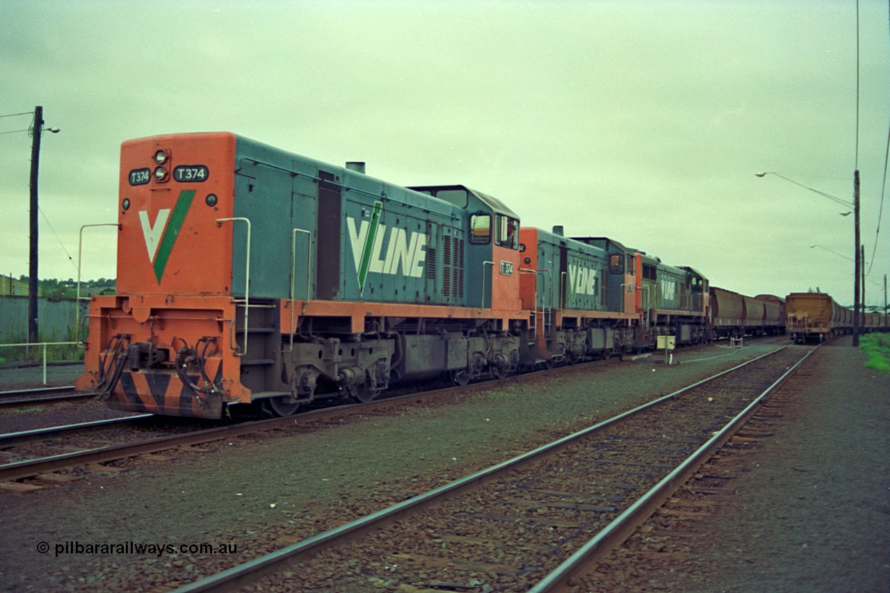 111-07
North Geelong grain arrivals yard, V/Line broad gauge locos T class T 374 Clyde Engineering EMD model G8B serial 64-329 and T class 3?? are cutting off from X class X 42 Clyde Engineering EMD model G26C serial 70-705 on the up Mt Gambier goods train 9192, loaded grain rake at right.
Keywords: T-class;T374;Clyde-Engineering-Granville-NSW;EMD;G8B;64-329;