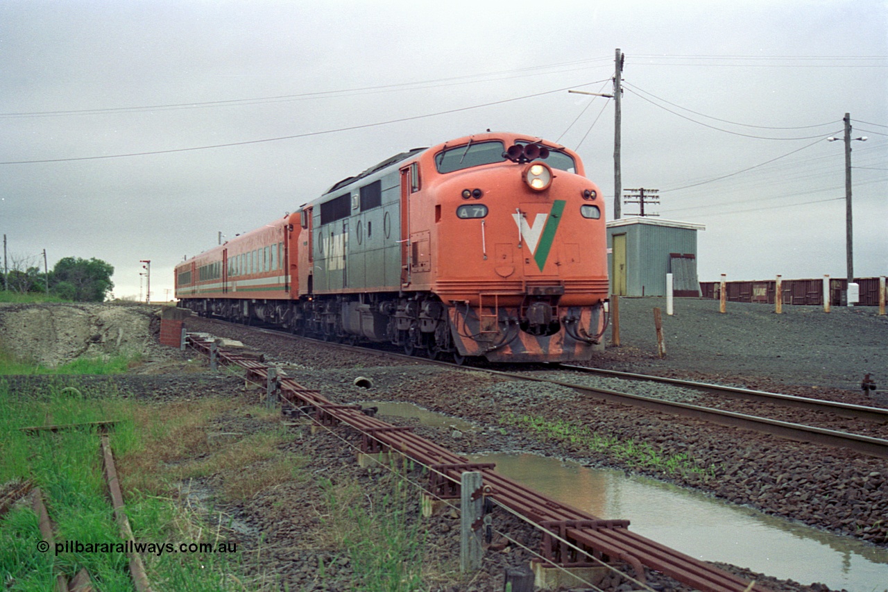 111-15
Gheringhap, broad gauge V/Line A class A 71 Clyde Engineering EMD model AAT22C-2R serial 83-1180 rebuilt from B 71 Clyde Engineering EMD model ML2 serial ML2-12 and N set departing with the down Ararat via Nth Geelong passenger train 8105, point rodding, signals wires and the former station platform are visible.
Keywords: A-class;A71;Clyde-Engineering-Rosewater-SA;EMD;AAT22C-2R;83-1180;rebuild;bulldog;