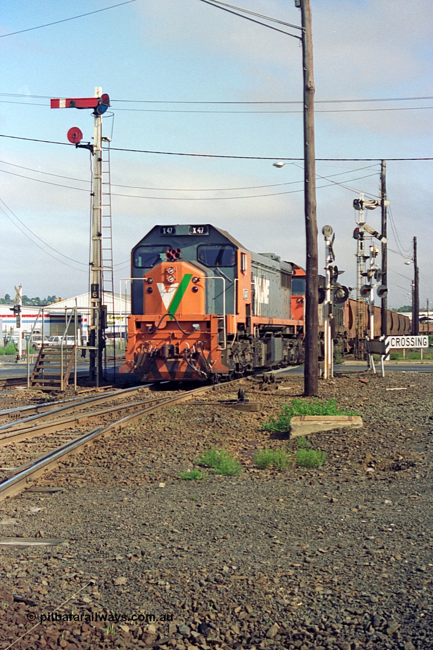 111-20
North Geelong grain arrivals yard, V/Line broad gauge loco X class X 47 Clyde Engineering EMD model G26C serial 75-794 and N class N 461 'City of Ararat' Clyde Engineering EMD model JT22HC-2 serial 86-1190 with a loaded grain rake crossing Separation St past semaphore signal posts 16, facing camera, and 14 pulled off for move.
Keywords: X-class;X47;Clyde-Engineering-Rosewater-SA;EMD;G26C;75-794;