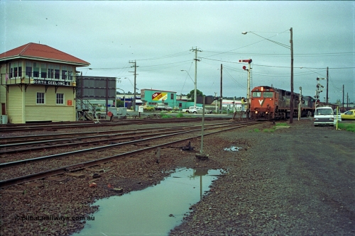 111-03
North Geelong C Box, V/Line broad gauge locos N class N 461 'City of Ararat' Clyde Engineering EMD model JT22HC-2 serial 86-1190 and X class X 47 Clyde Engineering EMD model G26C serial 75-794 pick up the electric staff for the grain loop, signaller on the staff exchange platform, signal box, ground dwarf disc signal, semaphore signal posts.
Keywords: N-class;N461;Clyde-Engineering-Somerton-Victoria;EMD;JT22HC-2;86-1190;