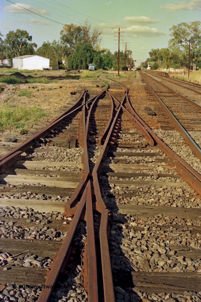 112-03
Violet Town broad gauge track view, looking north, double compound points, Siding A is removed, Siding B bottom left running behind lens, station in background, March 1994.
