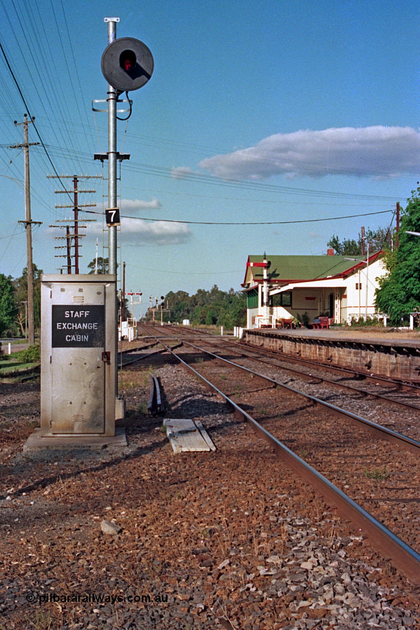 112-06
Violet Town broad gauge track view looking north, station overview, staff exchange cabin and cover for ground apparatus, cabin used when signal box is switched out, searchlight signal post 7, station building and signal bay, semaphore signal post 9 on platform, March 1994.
