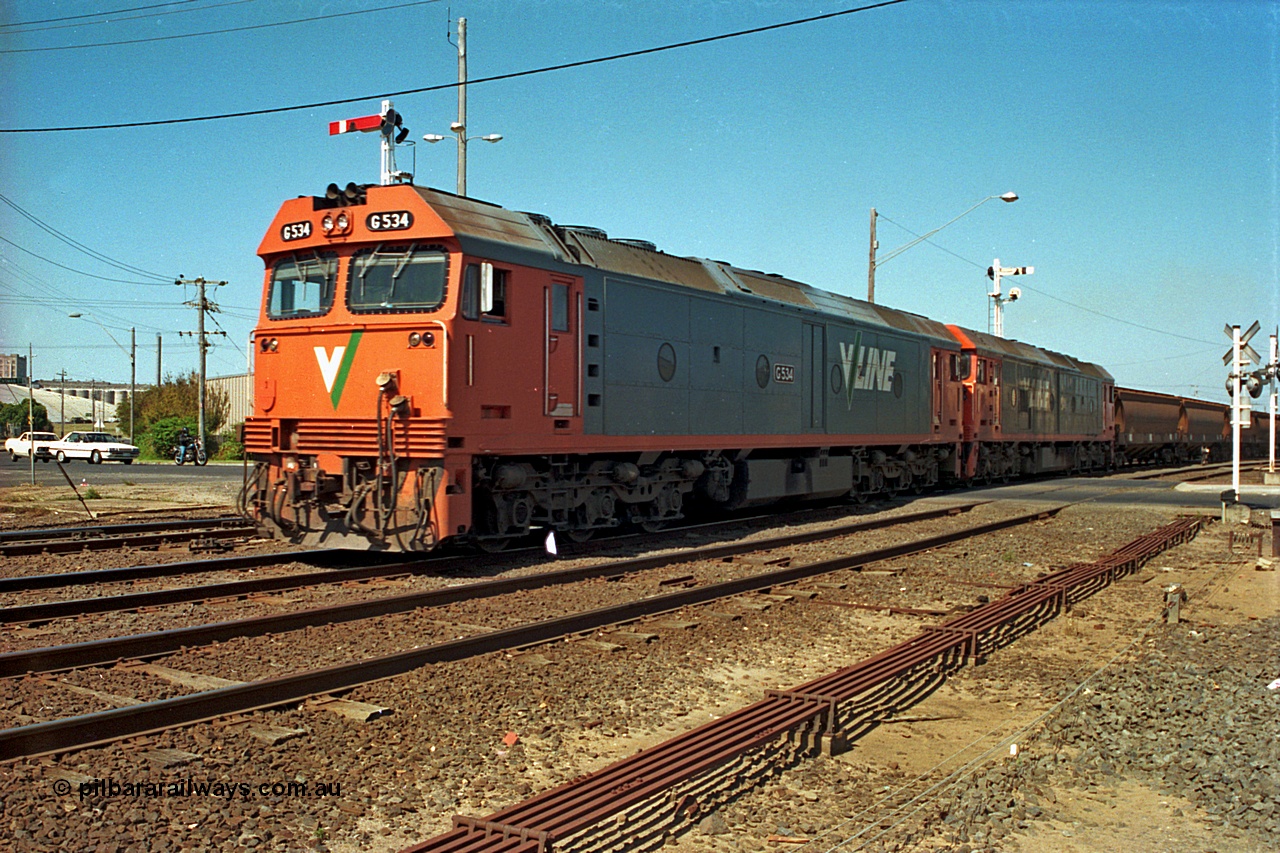 112-18
North Geelong C Box, V/Line broad gauge G class G 534 Clyde Engineering EMD model JT26C-2SS serial 88-1264 leads sister G class across Separation Street with an empty grain train departing, point rodding in foreground.
Keywords: G-class;G534;Clyde-Engineering-Somerton-Victoria;EMD;JT26C-2SS;88-1264;