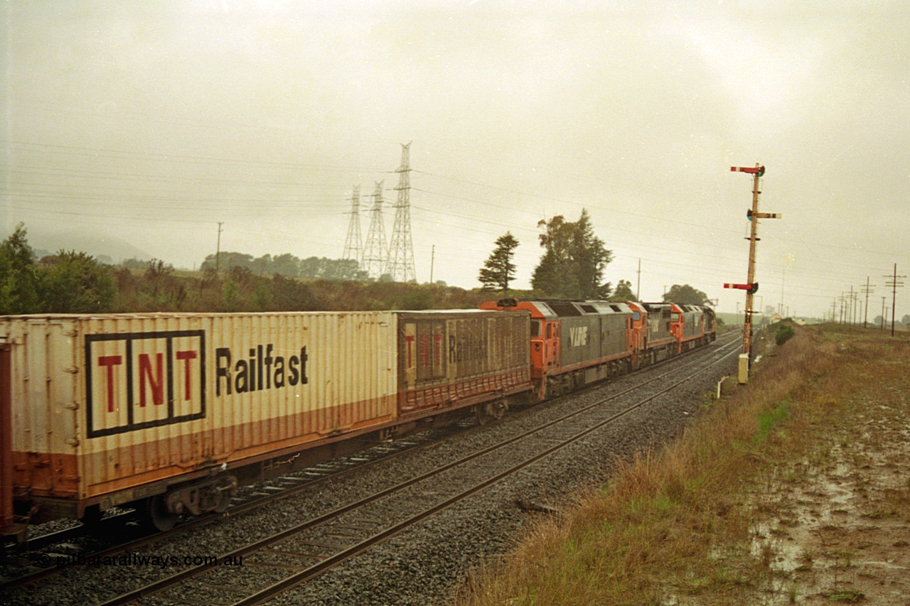 113-07
Warrenheip, up home semaphore signal post 11, V/Line broad gauge up Adelaide goods train 9150 behind the quad CGCG combo of C class C 506 Clyde Engineering EMD model GT26C serial 76-829, G class G 538 Clyde Engineering EMD model JT26C-2SS serial 89-1271, C class C 510 serial 76-833 and G class G 513 serial 85-1241, train 9150 up Adelaide goods, in miserable conditions, poor quality.
