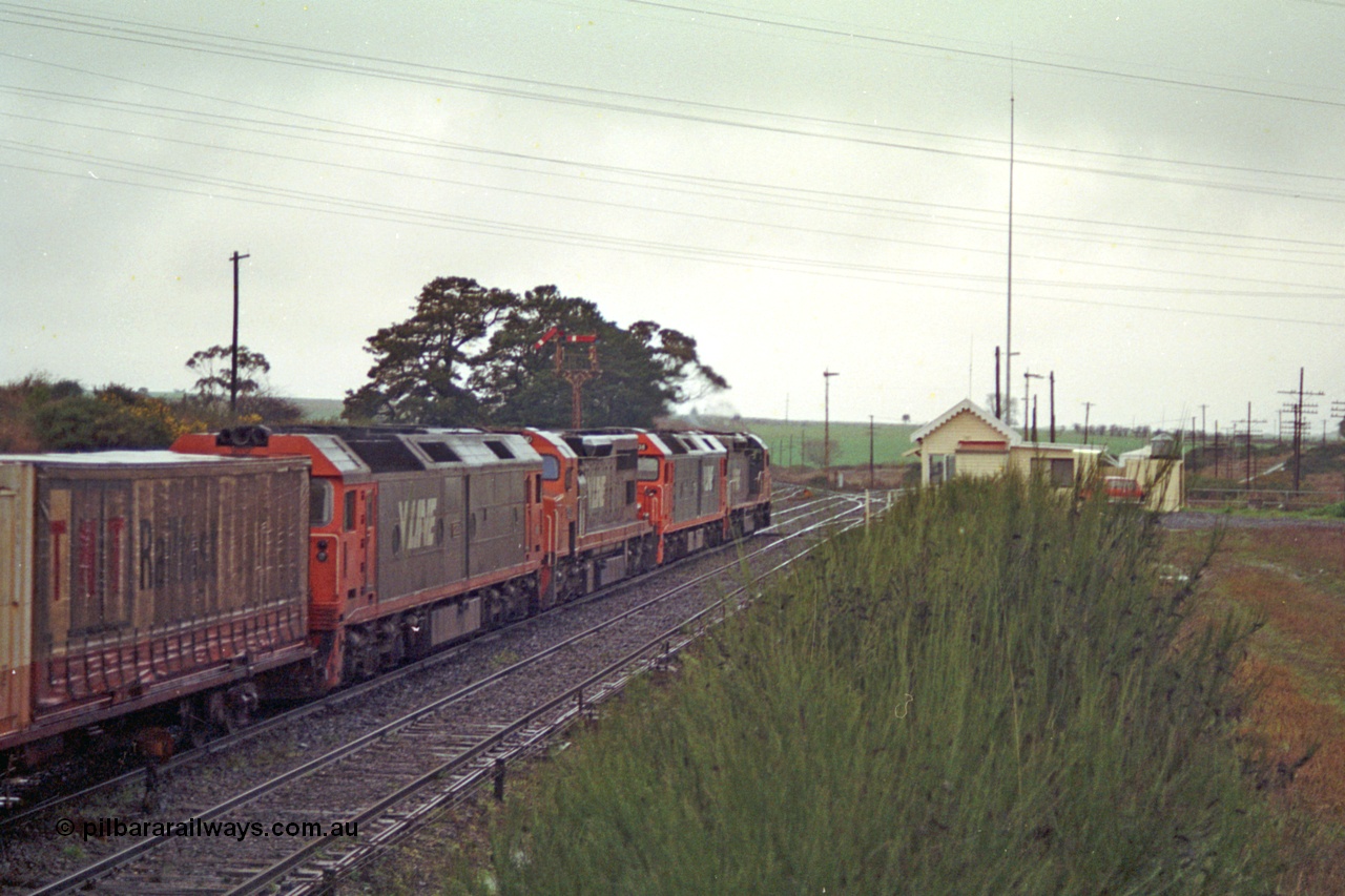 113-12
Warrenheip, V/Line broad gauge up Adelaide goods train 9150 behind the quad CGCG combo of C class C 506 Clyde Engineering EMD model GT26C serial 76-829, G class G 538 Clyde Engineering EMD model JT26C-2SS serial 89-1271, C 510 serial 76-833 and G 513 serial 85-1241, departing for Melbourne via Bacchus Marsh, semaphore signal post 9 pulled off for move, signal box and overview, in miserable conditions, poor quality.
