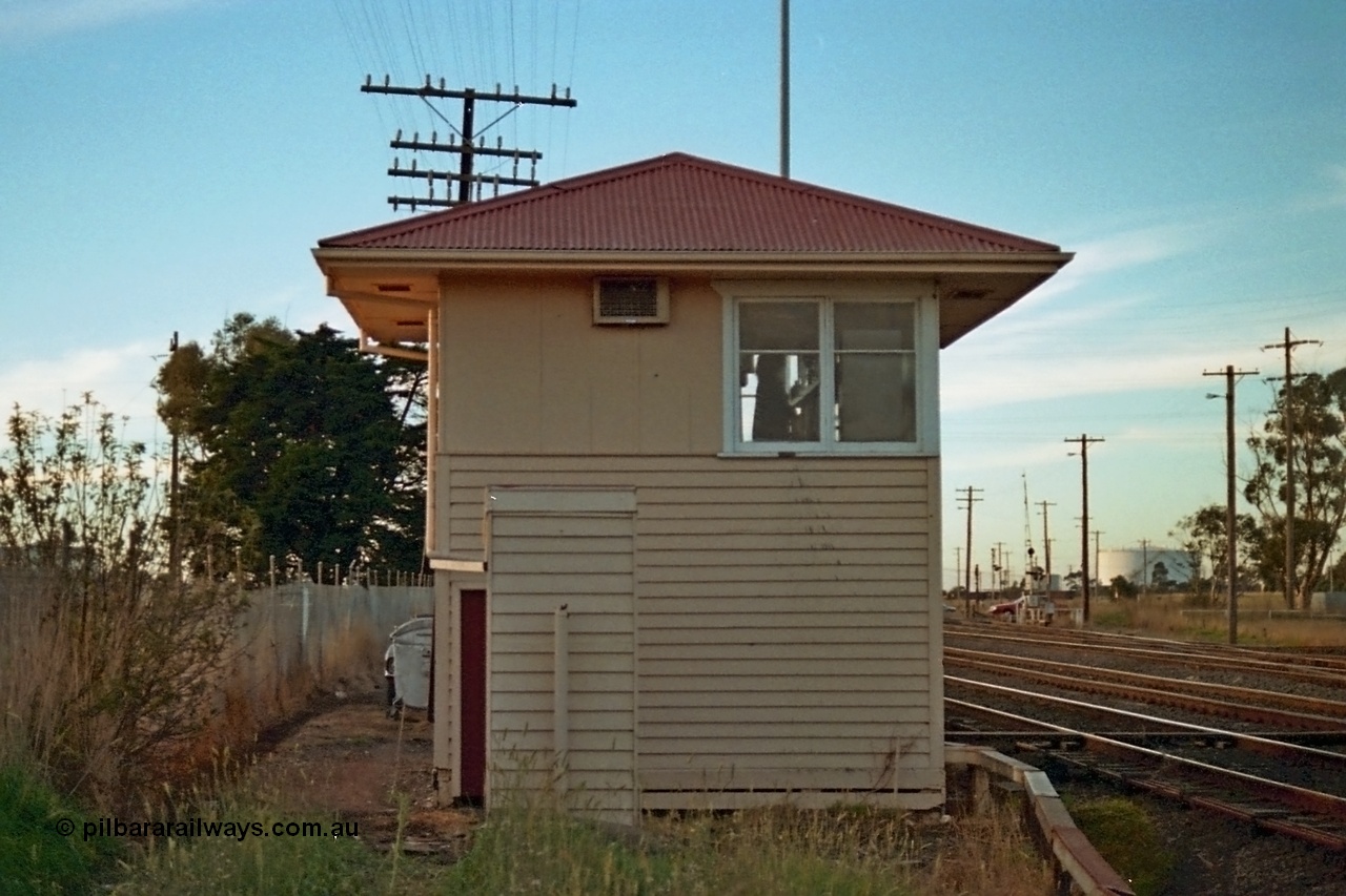 115-11
Somerton signal box, RHS elevation, looking north, grade crossing for Somerton Road visible, toilet in front of elevation, broad gauge lines in front of box with crossover to sidings visible crossing standard gauge line.
