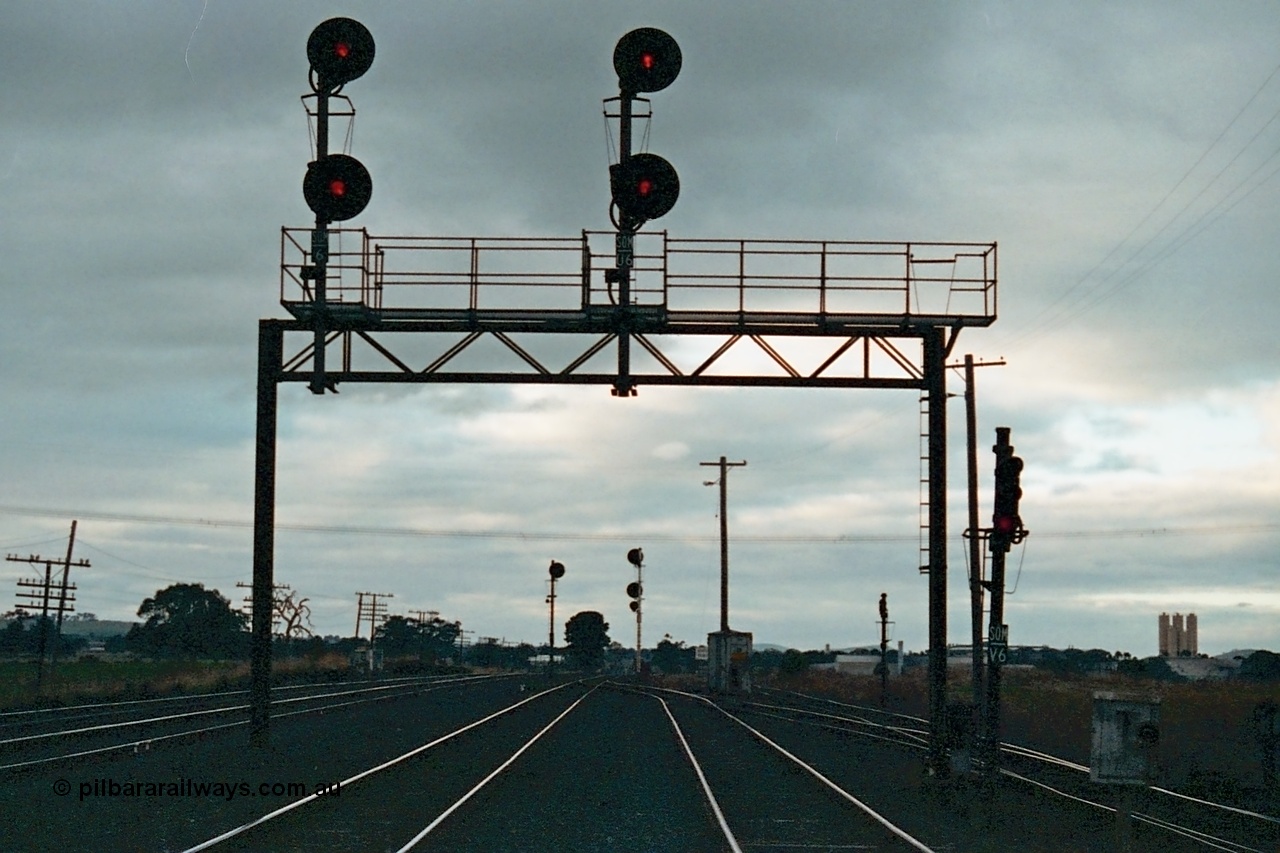 115-27
Somerton, standard gauge crossing loop, track overview, searchlight signals on gantry, looking north, North East broad gauge running lines on left, standard gauge sidings at right.
