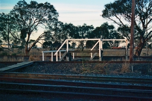 115-12
Somerton, staff exchange platforms for Ford's Siding / Upfield line, far platform for the broad gauge, with the standard gauge using the near platform, lines converge to dual gauge around curve, looking across the North East broad and standard gauge running lines.
