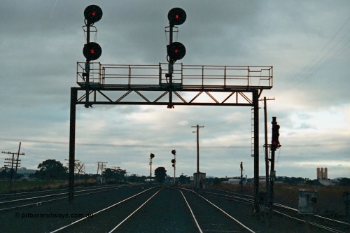 115-27
Somerton, standard gauge crossing loop, track overview, searchlight signals on gantry, looking north, North East broad gauge running lines on left, standard gauge sidings at right.
