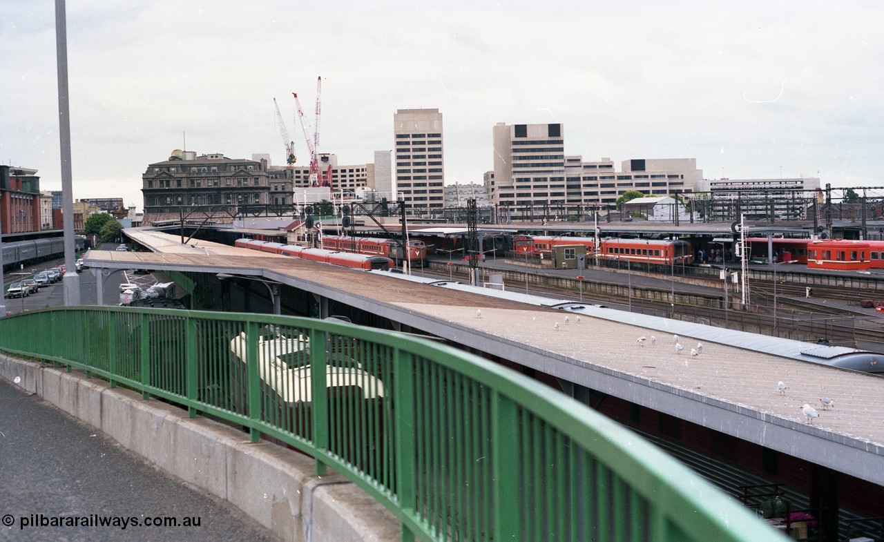 116-05
Spencer Street Station, view looking east from flyover, platform No.2 below with standard gauge car dock, South End Signal Box visible on Platform No's 3 and 4, V/Line N sets, A and N class locos, Crown Casino in the background behind the Spencer Street V/Line head office building, platform No.1 at far left.
