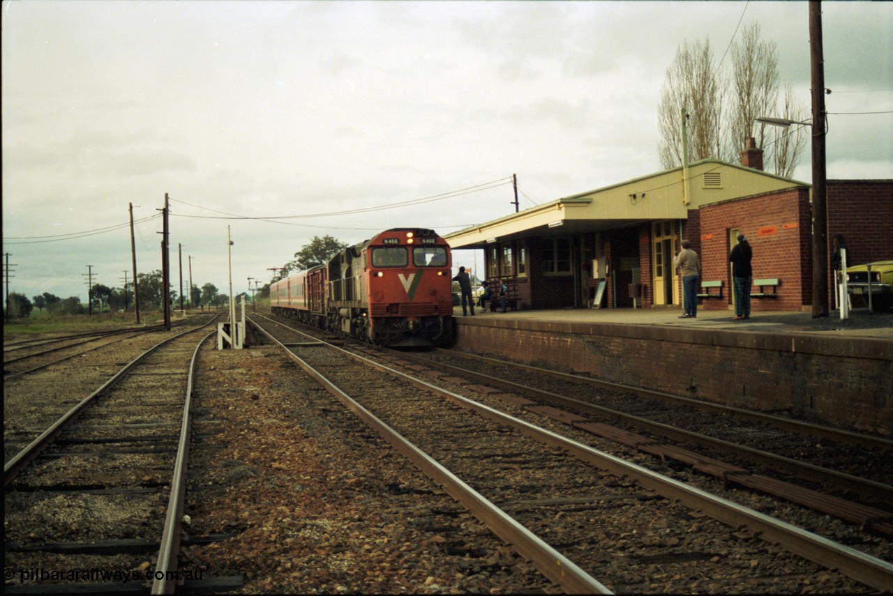 117-11
Springhurst, V/Line N class N 466 'City of Warrnambool' Clyde Engineering EMD model JT22HC-2 serial 86-1195 arrives with an N set and D van on an up Albury passenger train as the driver and signaller exchanges electric staffs, yard overview, station building and platform.
Keywords: N-class;N466;Clyde-Engineering-Somerton-Victoria;EMD;JT22HC-2;86-1195;