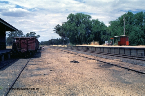 118-04
Strathmerton station yard overview, looking north, platform, bus style waiting shelter, signal bay, people picking coal, V/Line broad gauge VOBX type bogie open waggons.
Keywords: VOBX-type;
