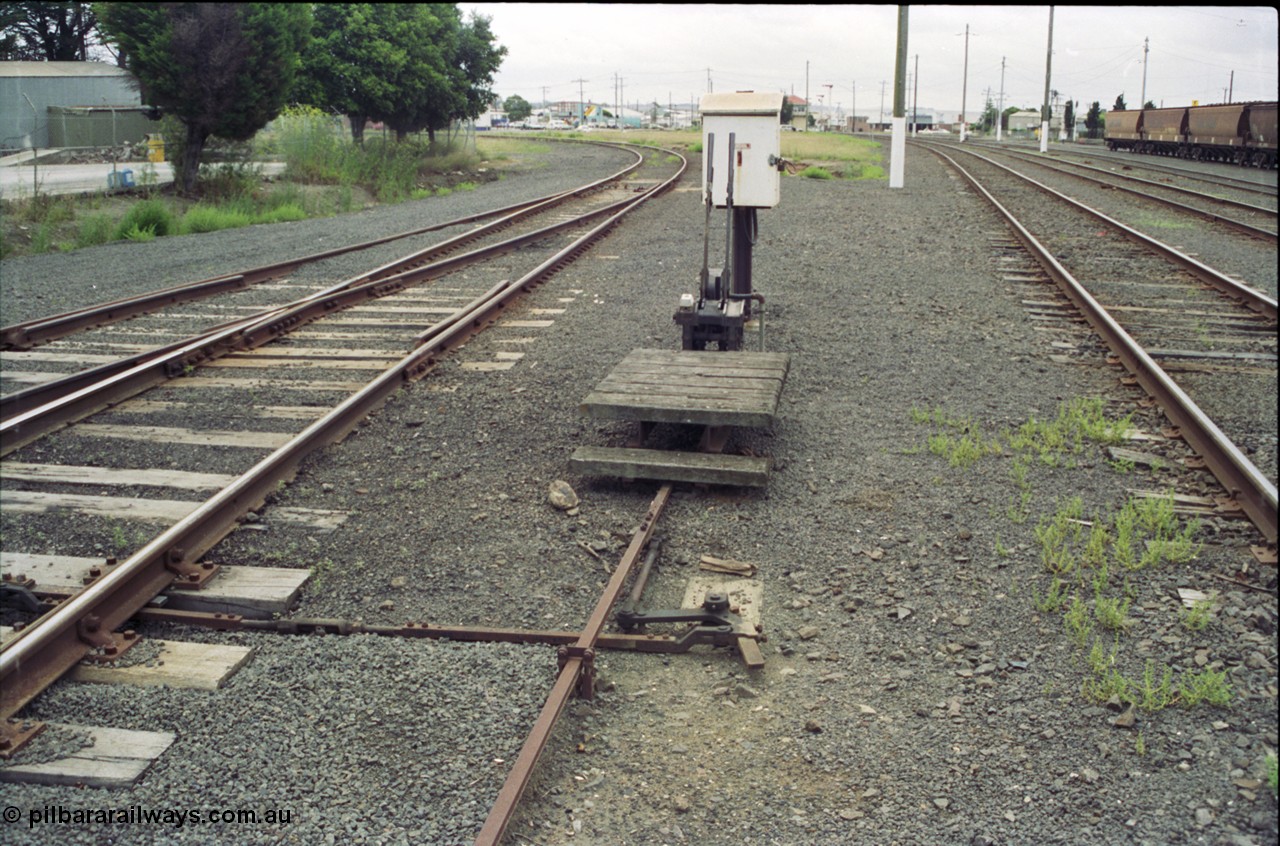 119-06
North Geelong yard view, 2 lever frame and telephone cabinet for the Fyansford line, Fyansford line curves round to the left, North Geelong C Box can be seen in the distance.
