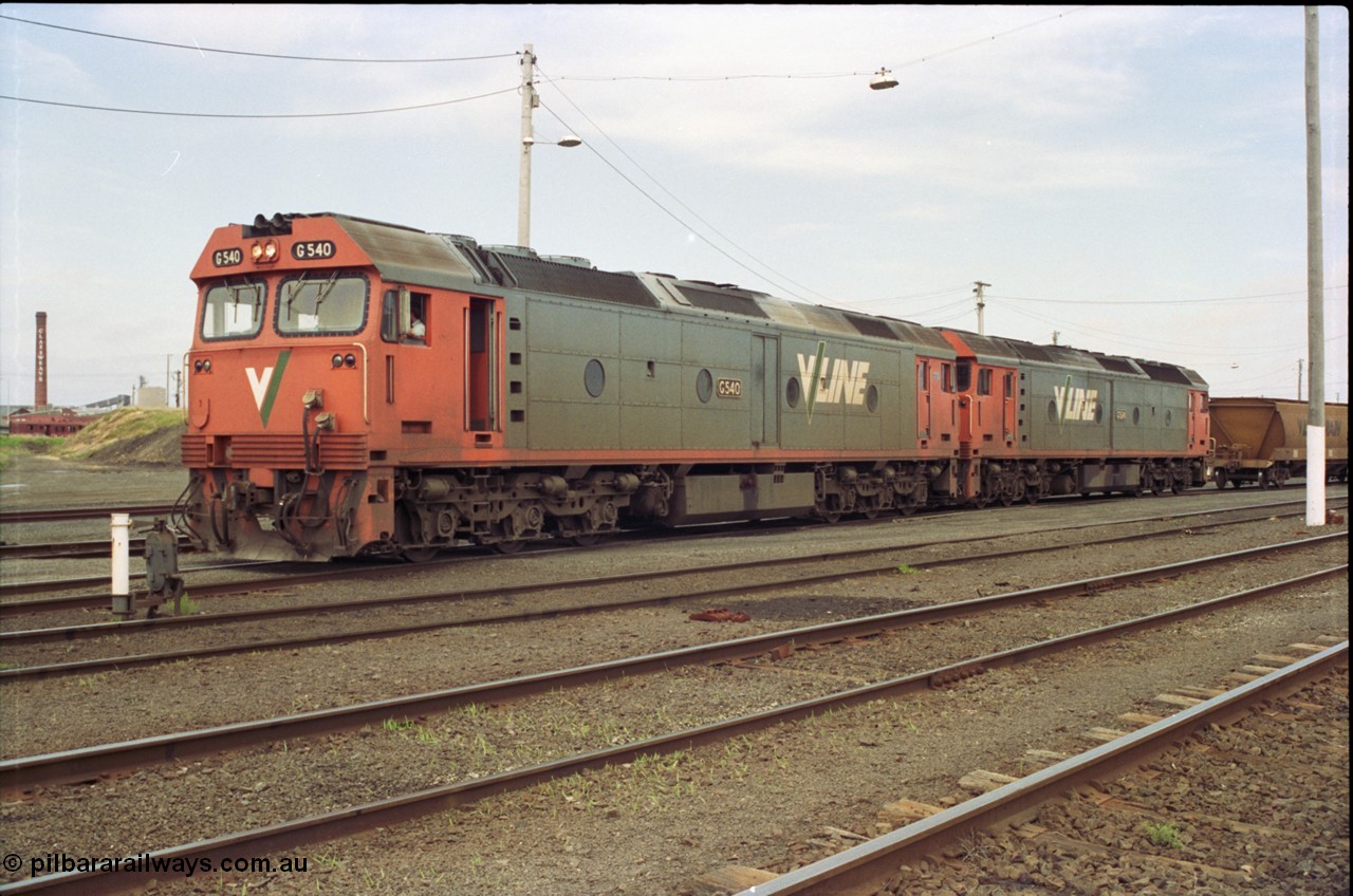 119-08
North Geelong yard, V/Line broad gauge locos G class G 540 Clyde Engineering EMD model JT26C-2SS serial 89-1273 and another G class waiting for shunters to couple up to empty grain rake to form down grain train 9125, ground dwarf signal 20.
Keywords: G-class;G540;Clyde-Engineering-Somerton-Victoria;EMD;JT26C-2SS;89-1273;