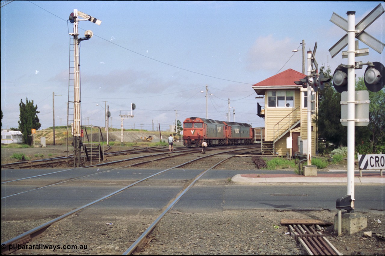 119-10
North Geelong C Box, V/Line broad gauge G classes G 540 Clyde Engineering EMD model JT26C-2SS serial 89-1273 and sister depart with down empty grain train 9125, looking across Separation Street, semaphore signal post 16 is pulled off for move, grade crossing, point rodding, signal box, 2nd person walking to loco with staff for section to Gheringhap.
Keywords: G-class;G540;Clyde-Engineering-Somerton-Victoria;EMD;JT26C-2SS;89-1273;