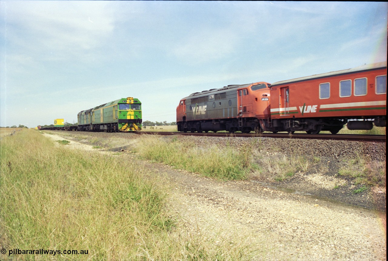 119-28
Parwan Loop, Australian National broad gauge locos BL class BL 29 Clyde Engineering EMD model JT26C-2SS serial 83-1013 and 700 class 703 AE Goodwin ALCo model DL500G serial G6059-1 with down Adelaide goods train 9145 is crossed by A class A7 9 Clyde Engineering EMD model AAT22C-2R serial 84-1188 rebuilt from B 79 Clyde Engineering EMD model ML2 serial ML2-20 with an up Bacchus Marsh passenger train.
Keywords: A-class;A79;Clyde-Engineering-Rosewater-SA;EMD;AAT22C-2R;84-1188;rebuild;bulldog;