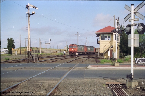 119-10
North Geelong C Box, V/Line broad gauge G classes G 540 Clyde Engineering EMD model JT26C-2SS serial 89-1273 and sister depart with down empty grain train 9125, looking across Separation Street, semaphore signal post 16 is pulled off for move, grade crossing, point rodding, signal box, 2nd person walking to loco with staff for section to Gheringhap.
Keywords: G-class;G540;Clyde-Engineering-Somerton-Victoria;EMD;JT26C-2SS;89-1273;