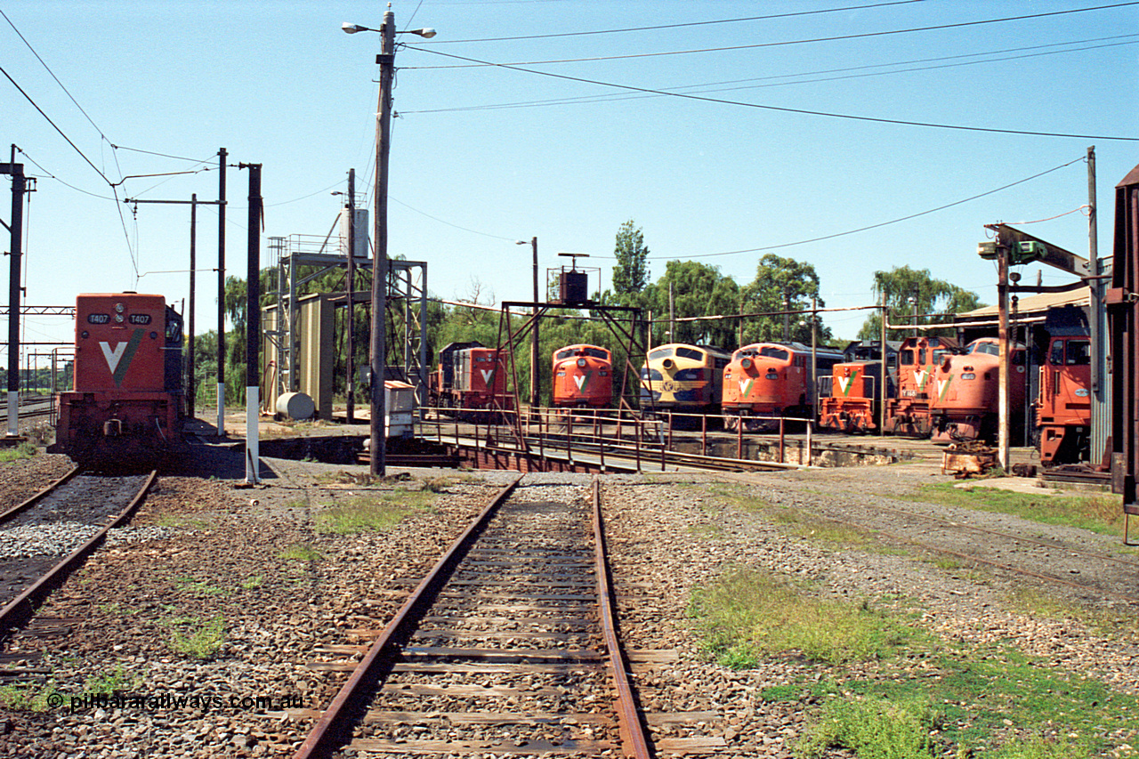 122-14
Traralgon loco depot overview from eastern end, V/Line broad gauge locos are all Clyde Engineering EMD models; T class T 407 model G18B serial 68-623, T class T 396 model G8B serial 65-426, A class A 77 model AAT22C-2R serial 83-1181 rebuilt from B class B 77 model ML2 serial ML2-18, B class B 75 serial ML2-16 still in VR livery, A class A 81 serial 85-1189 rebuilt from B class B 81 serial ML2-22, T class T 381 model G8B serial 64-336, Y class Y 168 model G6B serial 68-588, A class A 78 serial 84-1185 rebuilt from B class B 78 serial ML2-19 and G class G 512 model JT26C-2SS serial 84-1240.
