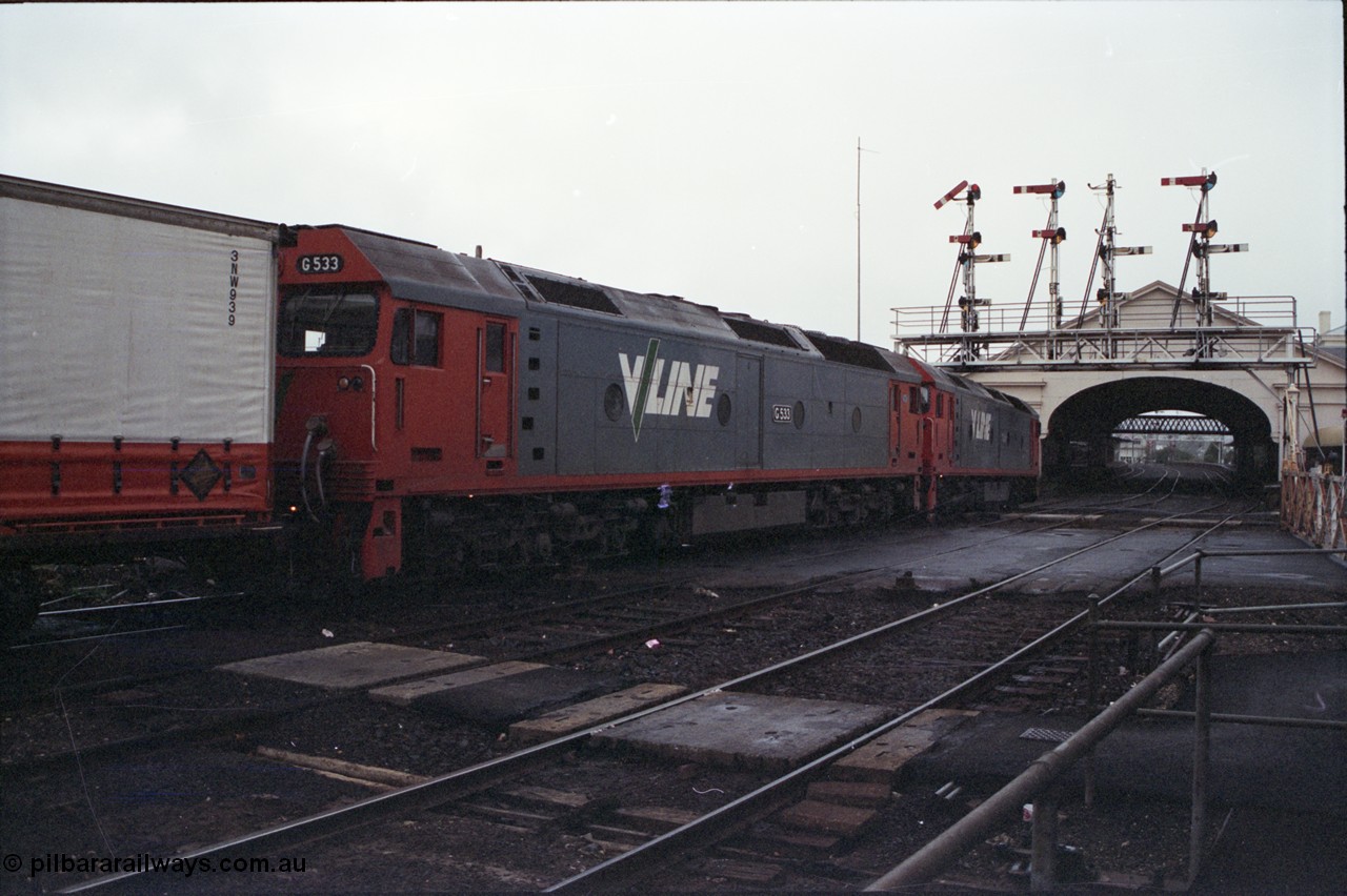 123-2-36
Ballarat station and canopy, semaphore signal gantry, Lydiard Street grade crossing, V/Line broad gauge G classes G 528 Clyde Engineering EMD model JT26C-2SS serial 88-1258 and G 533 Clyde Engineering EMD model JT26C-2SS serial 88-1263 with up Adelaide goods train 9150.
Keywords: G-class;G528;Clyde-Engineering-Somerton-Victoria;EMD;JT26C-2SS;88-1258;