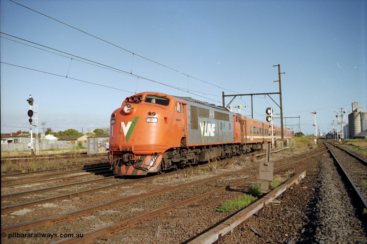 124-05
Sunshine V/Line broad gauge down passenger train with V/Line A class A 71 Clyde Engineering EMD model AAT22C-2R serial 83-1180 rebuilt from B 71 Clyde Engineering EMD model ML2 serial ML2-12 and N set, standard gauge Sunshine Loop up home signal on the far left, Newport Loop Line on the right.
Keywords: A-class;A71;Clyde-Engineering-Rosewater-SA;EMD;AAT22C-2R;83-1180;rebuild;bulldog;