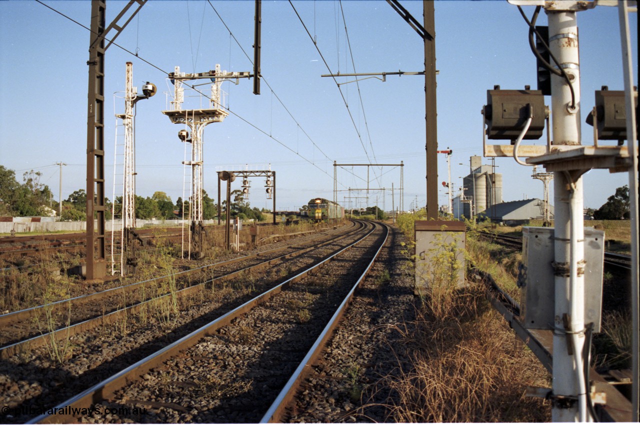 124-14
Sunshine looking from the passenger lines across to the Independent Through Goods lines, signal post 71 at camera, disc and semaphore signal posts 31 and 31B for control of the Independent Trough Goods lines, down Adelaide broad gauge goods train on approach behind BL classes BL 30 and BL 35 in AN livery, standard gauge Sunshine Loop to the left of train, Newport Loop Line and GEB sidings at far right
