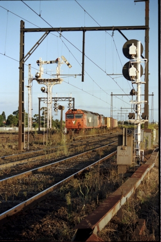 124-23
Sunshine V/Line down broad gauge Adelaide goods train with G class G 512 Clyde Engineering EMD model JT26C-2SS serial 84-1240 and X class Clyde Engineering EMD model G26C serial 75-798, view across passenger lines with semaphore signal post 31 pulled off for move to No.3 road, train is on Independent Through Goods Line, standard gauge Sunshine Loop is on the left of the train, passenger line searchlight signal post 71 is on the right
Keywords: G-class;G512;Clyde-Engineering-Rosewater-SA;EMD;JT26C-2SS;84-1240;