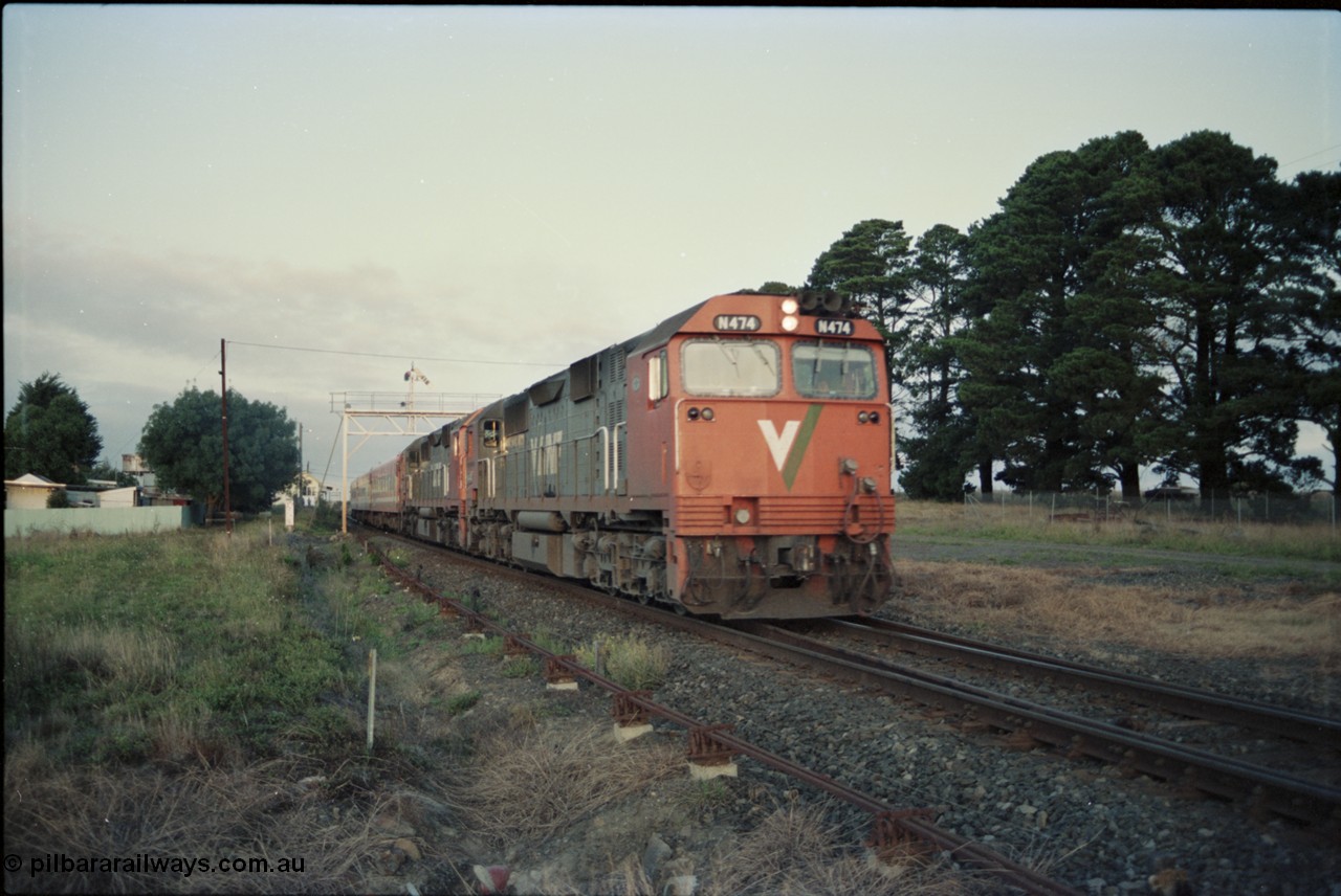 125-05
Ballan broad gauge V/Line N class N 474 'City of Traralgon' Clyde Engineering EMD model JT22HC-2 serial 87-1203 with another N class and N set on a down passenger train departing, early evening shot, signal gantry.
Keywords: N-class;N474;Clyde-Engineering-Somerton-Victoria;EMD;JT22HC-2;87-1203
