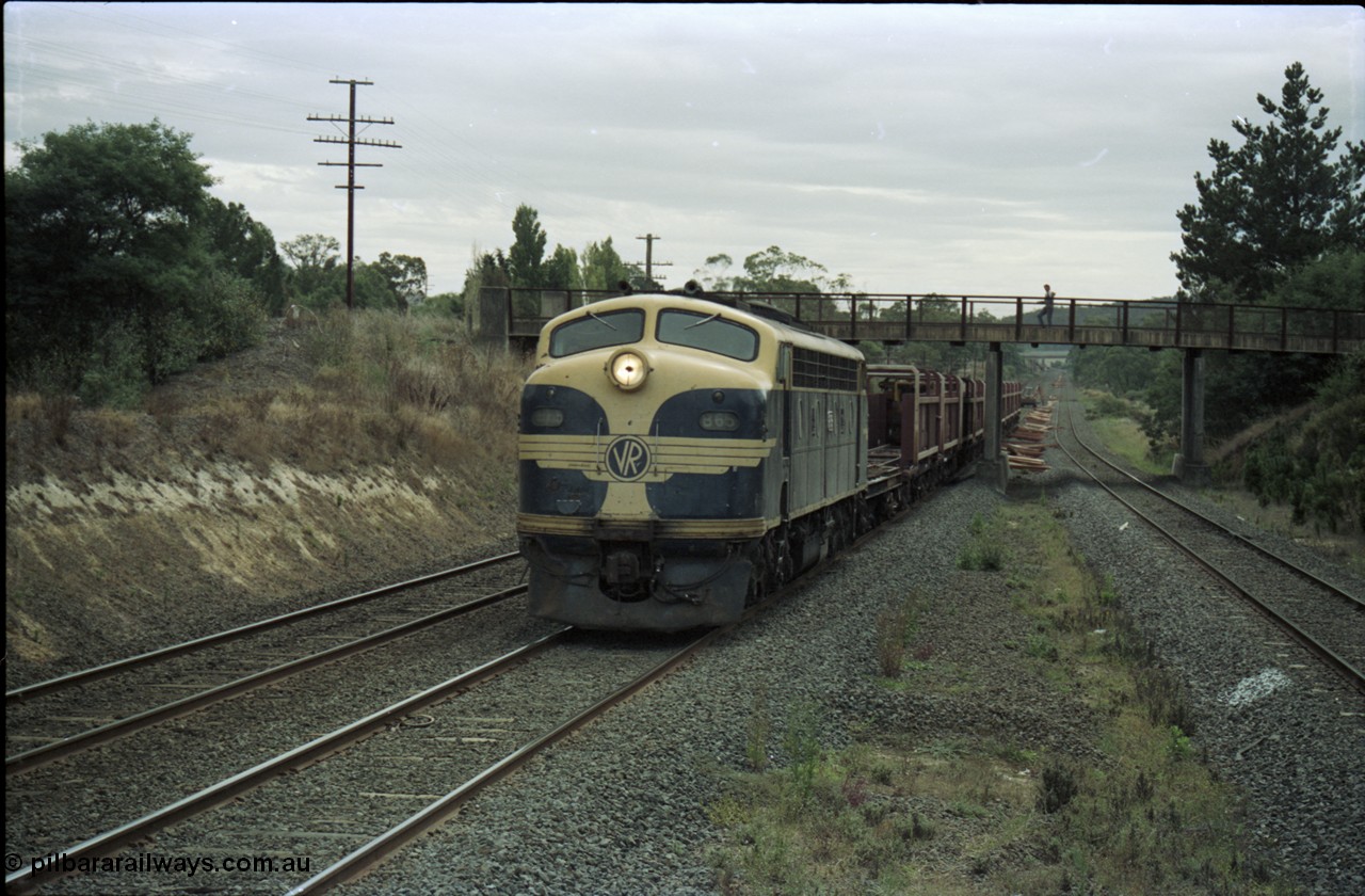 125-15
Wandong passing under Kilmore - Wandong Rd, V/Line broad gauge B class Clyde Engineering EMD model ML2 serial ML2-6 still in Victorian Railways livery leads a sleeper discharge train on the up broad gauge line, discharging sleepers.
Keywords: B-class;B65;Clyde-Engineering-Granville-NSW;EMD;ML2;ML2-6;bulldog;